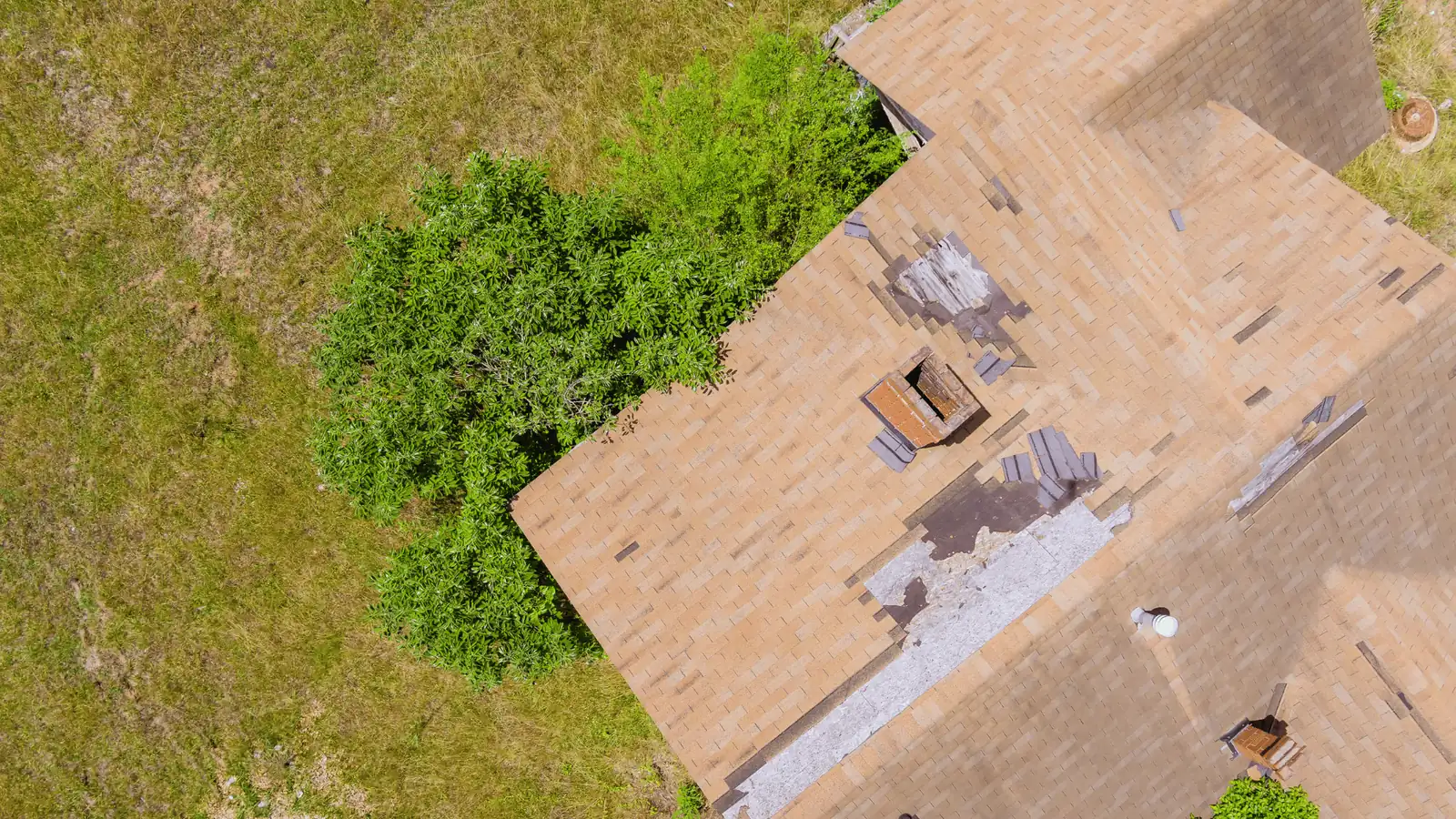 Aerial view of damaged roof shingles caused by storm activity