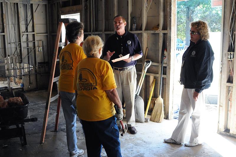 Disaster relief volunteers consulting with officials inside a building undergoing repair (FEMA photo by Andrea Booher)